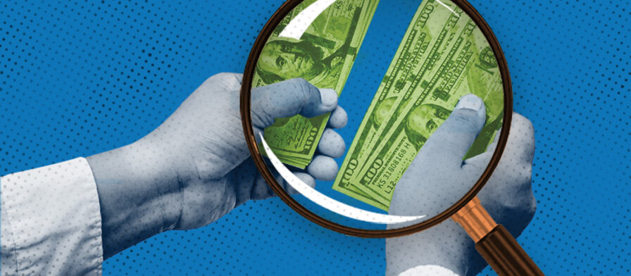 Magnifying glass looking at money on a blue background